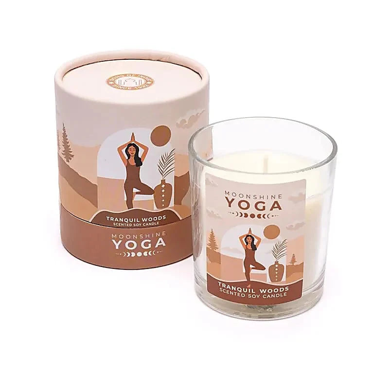 duftlys med brune nuancer og et etiket med en dame der laver yoga. lyset er i et glas